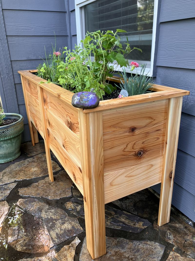 Side view of the tall custom planter box showing its legs and cedar grain
