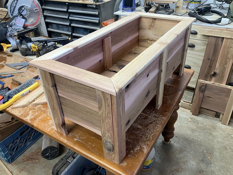 A cedar planter box being assembled on a workbench in the shop